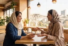 گفتگوی صمیمی دو زن جوان ایرانی در کافه با زبان بدن باز و ارتباط چشمی موثر برای جلب اعتماد