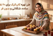 خانم خانهدار ایرانی با لبخند در یک آشپزخانه روشن، در حال سرو یک سینی چوبی پر از کاپ کیکهای تازه ساده و شکلاتی در کنار چای. (آموزش طرز تهیه کاپ کیک برای ۲۰ نفر)